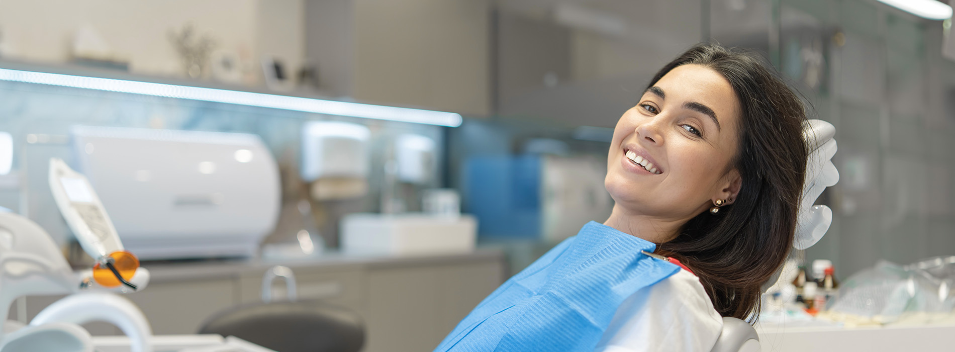 A well-lit reception area with a desk, computer monitor, and potted plant.